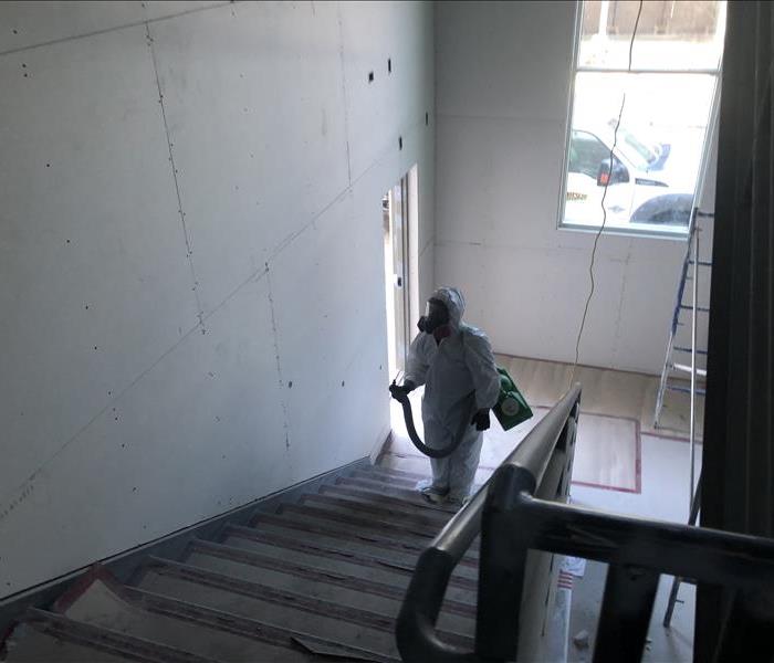 SERVPRO employee disinfecting stairwell