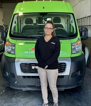 Picture of Jessica Harris the Office Manager standing in front of SERVPRO vehicle